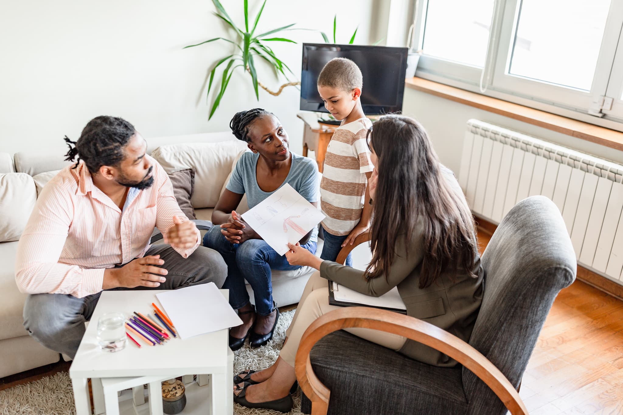 Family meeting with ABA therapy team in a home setting